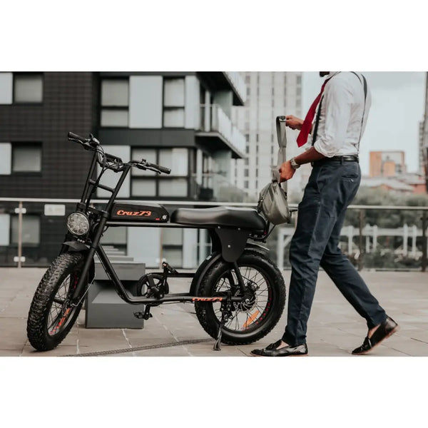 Side view of a Cruz73 Retro Fat Tyre electric bike parked in an urban setting.