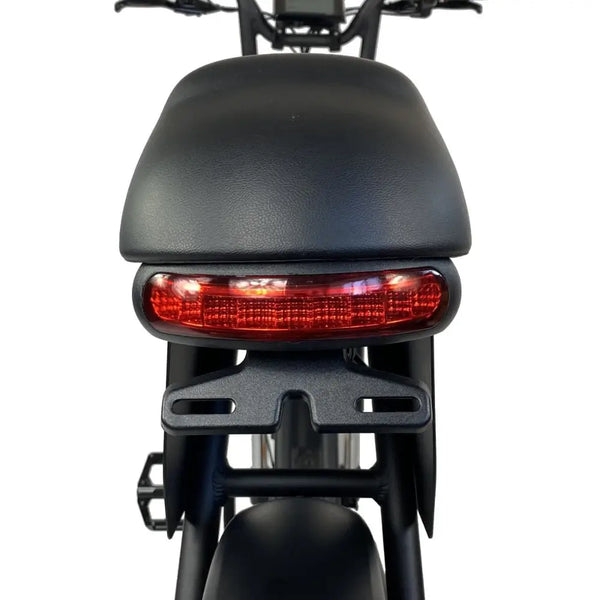 Close-up of the Cruz73 Unlimited Retro Fat Tyre 750W electric bike rear LED light beneath the seat.