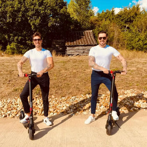 Two friends enjoying a sunny leisure ride on their Cruzaa Commuta 350W electric scooters on a quiet country road