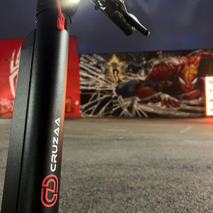 Artistic low-angle shot of the Cruzaa Commuta scooter stem against a vibrant urban graffiti wall.