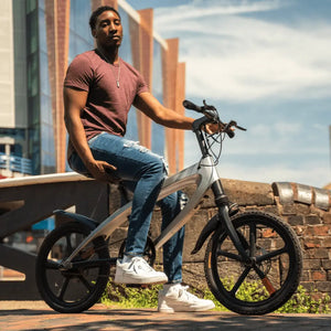 A rider paused on a city bridge while testing the Cruzaa electric bike, displaying the bike's relaxed riding position and modern aesthetics.