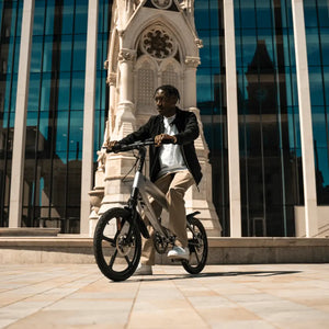 A man stopping on the Cruzaa electric bike in a paved city square, highlighting the bike's stylish design suitable for modern urban commuting.