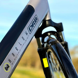 Detail shot of the "Harlow Electro-Infusion" branding on the silver downtube of the Dallingridge electric bike, showing the integrated battery compartment.