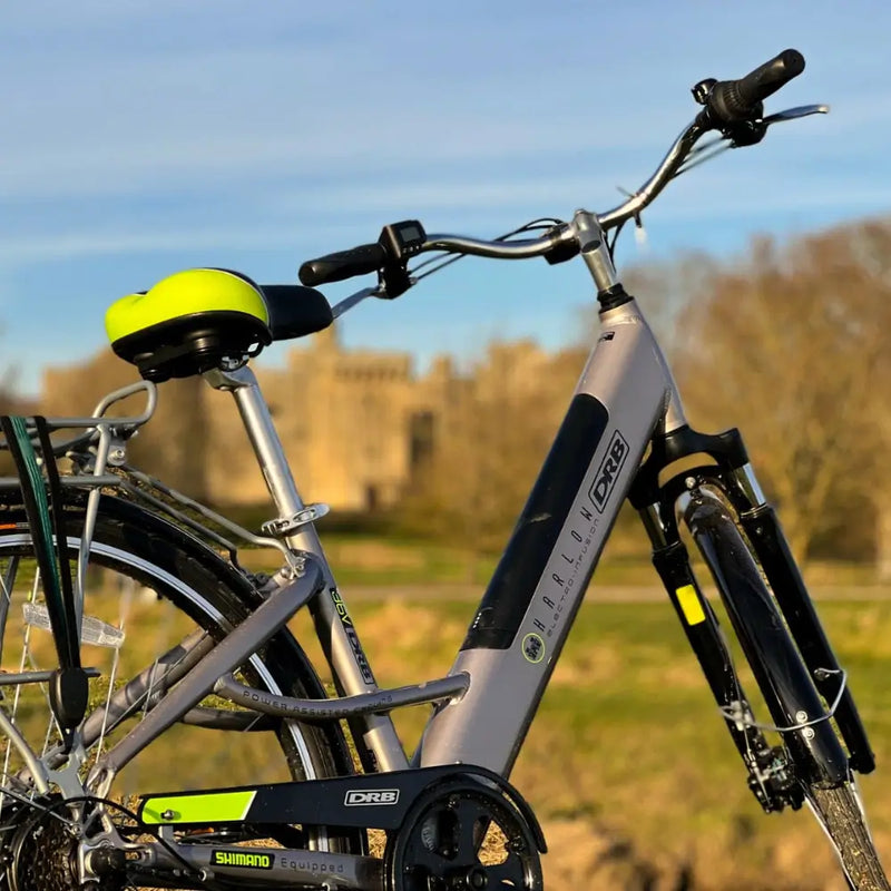 Angled side view of the silver Dallingridge Harlow step-through electric bike highlighting the integrated battery and suspension fork.