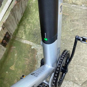 Detail view of the silver frame downtube on the Dallingridge Malvern showing the integrated 14Ah battery, charging port, and power indicator light.