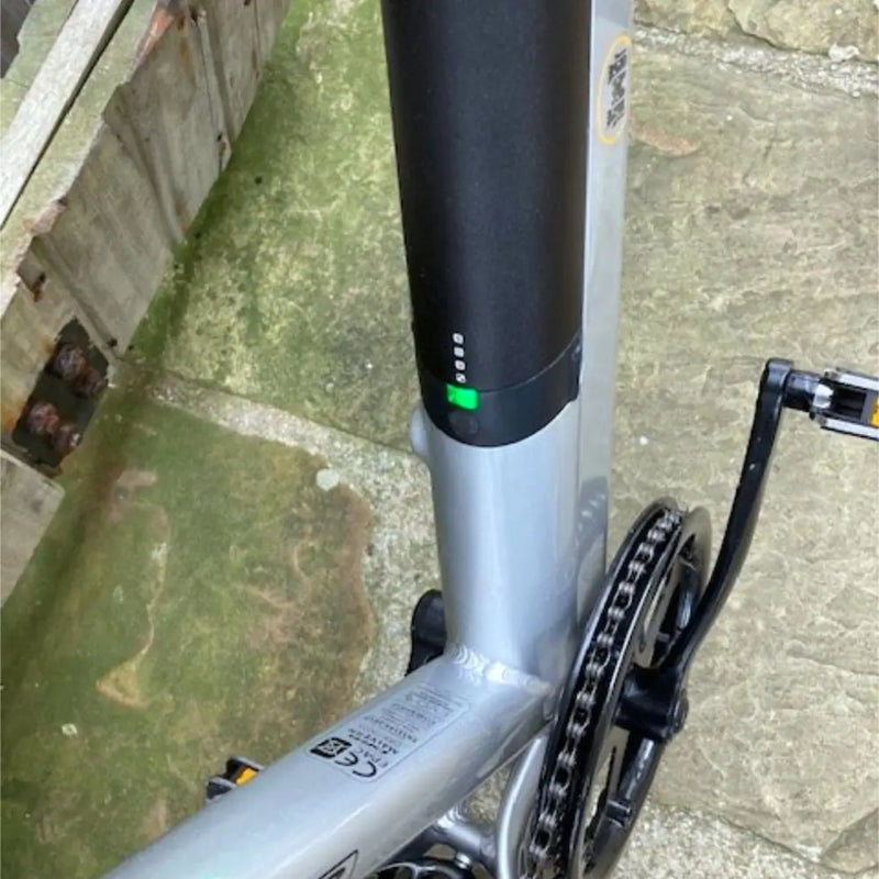 Detail view of the silver frame downtube on the Dallingridge Malvern showing the integrated 14Ah battery, charging port, and power indicator light.