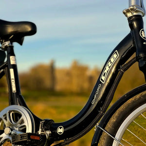 Detail shot of the curved low step-through frame on the black Dallingridge Oxford electric bike, highlighting the model branding and central folding hinge.
