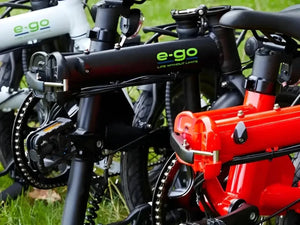 Close-up of a red and black e-bike with 'e-go' branding on a grassy background.