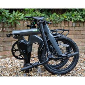 E-Go CarbonLite 3S fully folded electric bike standing upright, demonstrating its compact size.