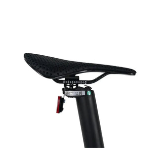 Close-up of the perforated saddle and integrated rear light on the CarbonLite e-bike's seatpost.