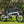 Mint green E-Go Max+ folding electric bike parked on a sunny lawn, highlighting its robust aluminium frame and 20-inch alloy wheels suitable for outdoor leisure.