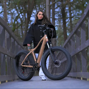 a woman holding the e-movement thunder v4 emb in an outdoor setting.