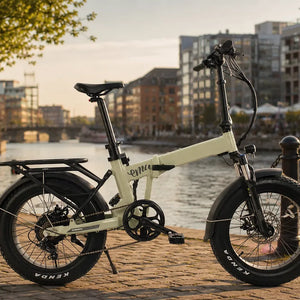 Emu Fat Tyre folding electric bike parked on a riverside promenade at sunset