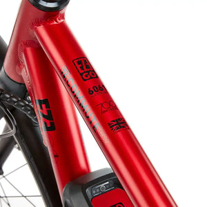 Detail of the red frame tubing on the Commute EX Gents, featuring the "Commute EX" model name and technical specifications like "6061 Superlight Aluminium" and "700c Urban" decals.