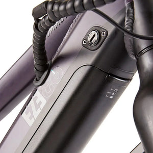 Close-up of the EZEGO Commute Int's battery seamlessly integrated into the downtube, featuring a security lock and LED charge level indicator.