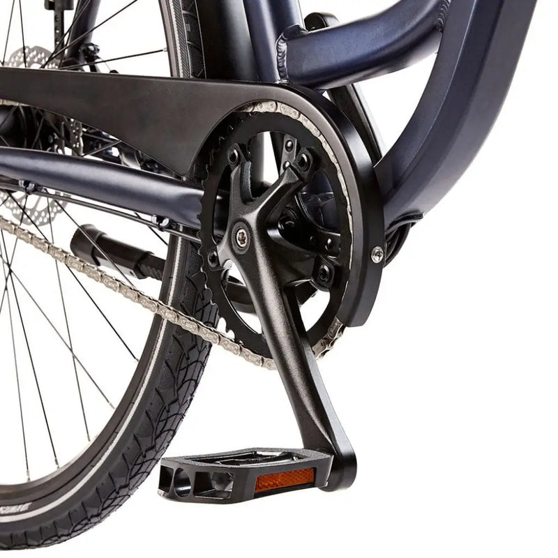 Detail view of the black crankset, pedals, and protective chain guard on the EZEGO Step NX.