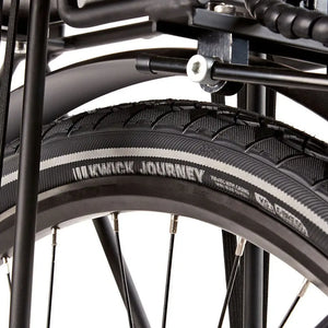 Close-up of the Kenda Kwick Journey tire tread and reflective sidewall strip on the EZEGO Step NX wheel.