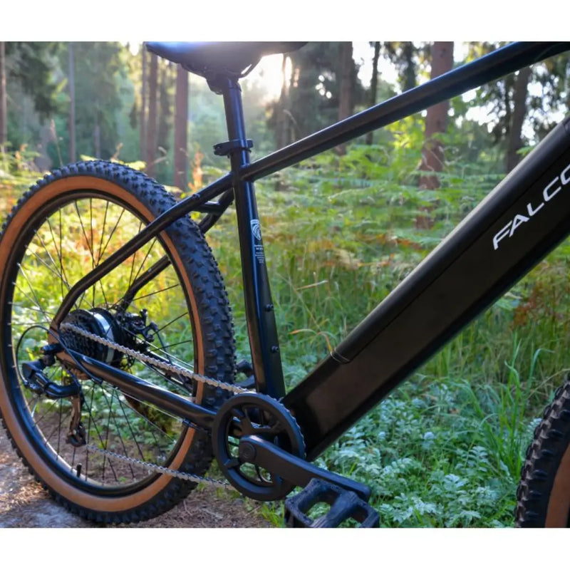 Close-up lifestyle shot of the Falcon Turbine 250W electric mountain bike's rear frame and wheel.