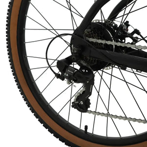 Rear view of the Falcon Turbine on a forest trail, showcasing the 250W rear hub motor, Shimano derailleur, and aggressive off-road tire tread for traction.