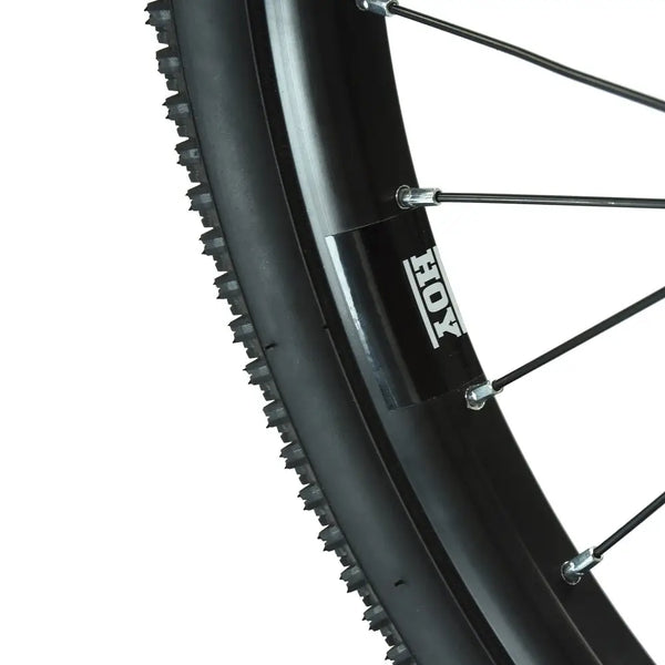Extreme close-up of the tire tread pattern and HOY branded rim of the Pentland kids' bike wheel.