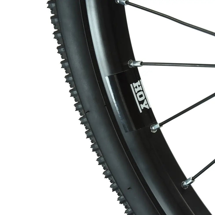 Extreme close-up of the tire tread pattern and HOY branded rim of the Pentland kids' bike wheel.