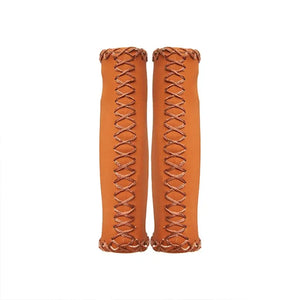 A pair of Hygge classic brown leather bicycle grips featuring a vintage cross-stitched pattern and ergonomic shape.