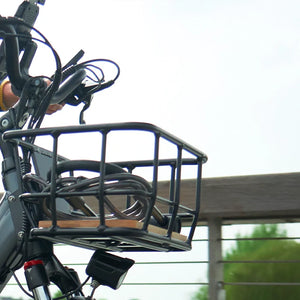 A cyclist commuting across a bridge on a Hygge electric bike, demonstrating the practical use of the front cargo basket for carrying daily essentials.