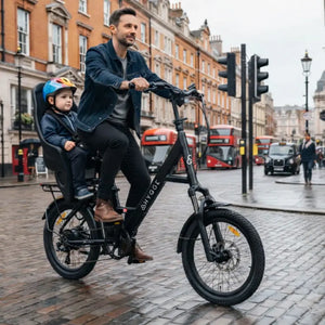 Rider using Hygge Herlev electric bike with child seat in city street showing family commuting use.