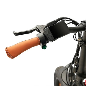 Close-up of a Hygge electric bike handlebar featuring ergonomic brown leather grips installed next to the LCD display and brake levers.