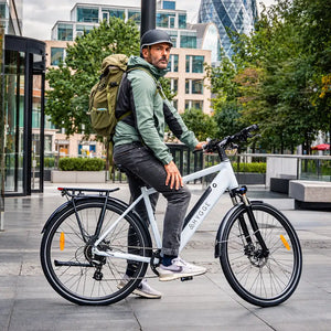 Rider with a rucksack on the white Hygge Lossø commuter electric bike in the city.