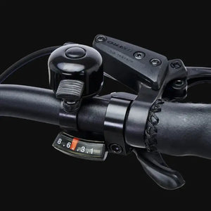Handlebar detail of Hygge Lossø electric bike showing bell, brake lever and gear shifter control system.