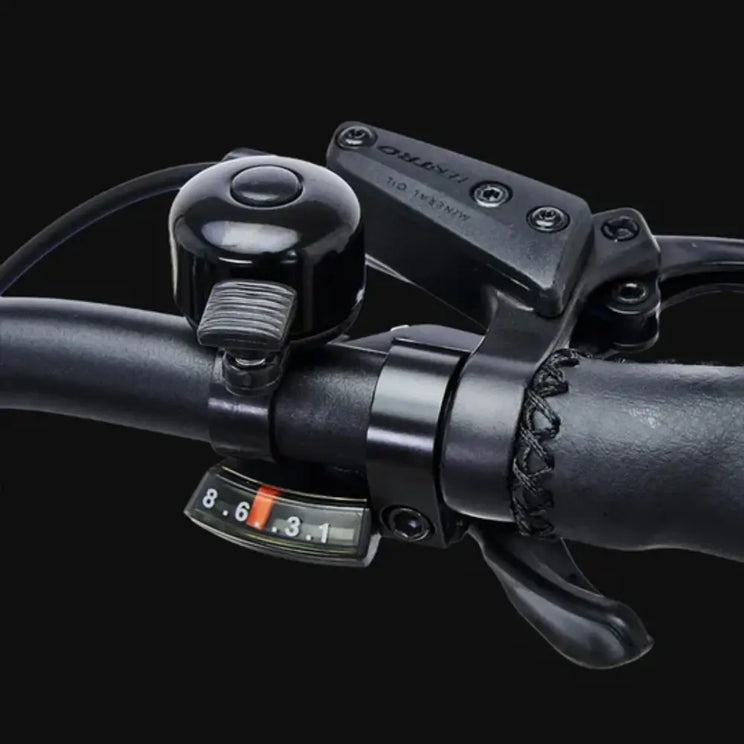 Handlebar detail of Hygge Lossø electric bike showing bell, brake lever and gear shifter control system.