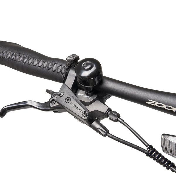 Close-up of the handlebar featuring the Tektro brake lever, bell, and Shimano components.