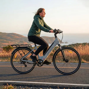 Woman riding Hygge Lossø step-through electric bike on a scenic road, highlighting comfort and leisure riding.