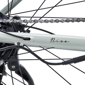 Detail of the "Nivø" model name written on the light grey frame near the rear wheel.