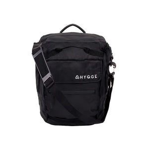 A black Hygge pannier bag using the detachable shoulder strap, showcasing its versatility as a messenger bag when off the bike.