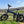 Hygge Sorø Fat Tyre Folding Electric Bike parked on grass with countryside hills in the background