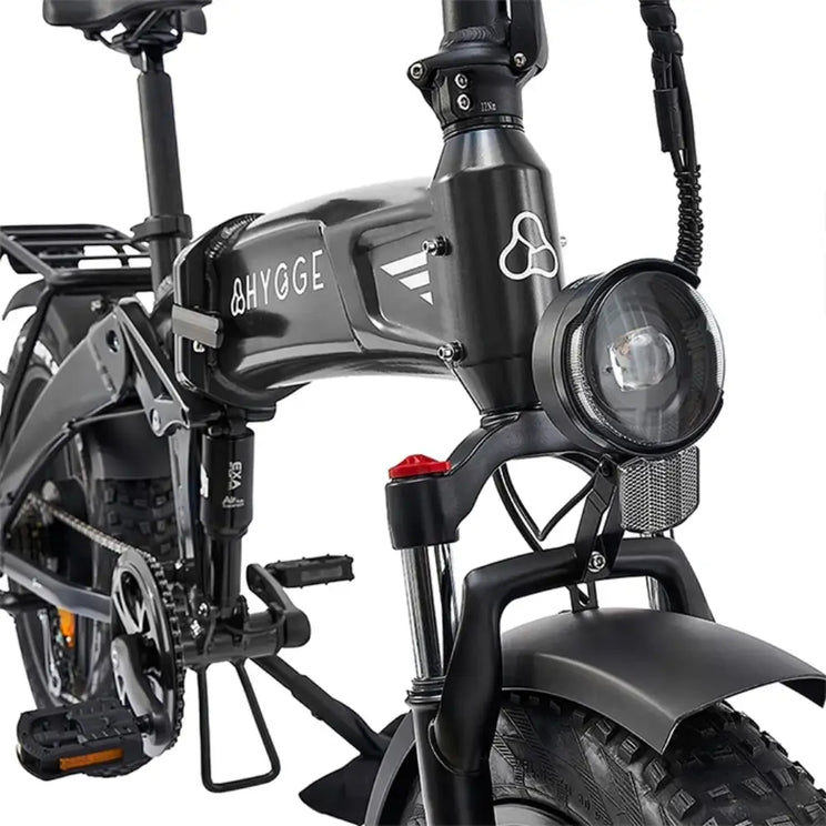 The black Hygge Sorø electric bike front suspension fork with integrated LED headlight for improved comfort and visibility.