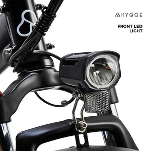 Front view of the Hygge Vester 2025 showing the large, bright LED headlight and front suspension fork for smooth riding.