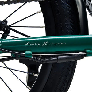 Close-up of the 'Lars Hansen' signature on the green frame, highlighting the bike's Danish design heritage.