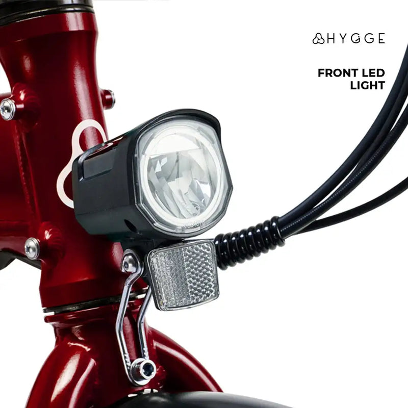Detail shot of the integrated front LED headlight on the red Hygge Virum, designed for night riding visibility.