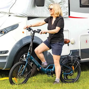 Rider using Hygge Virum folding electric bike near a camper van, highlighting portability and outdoor lifestyle use.