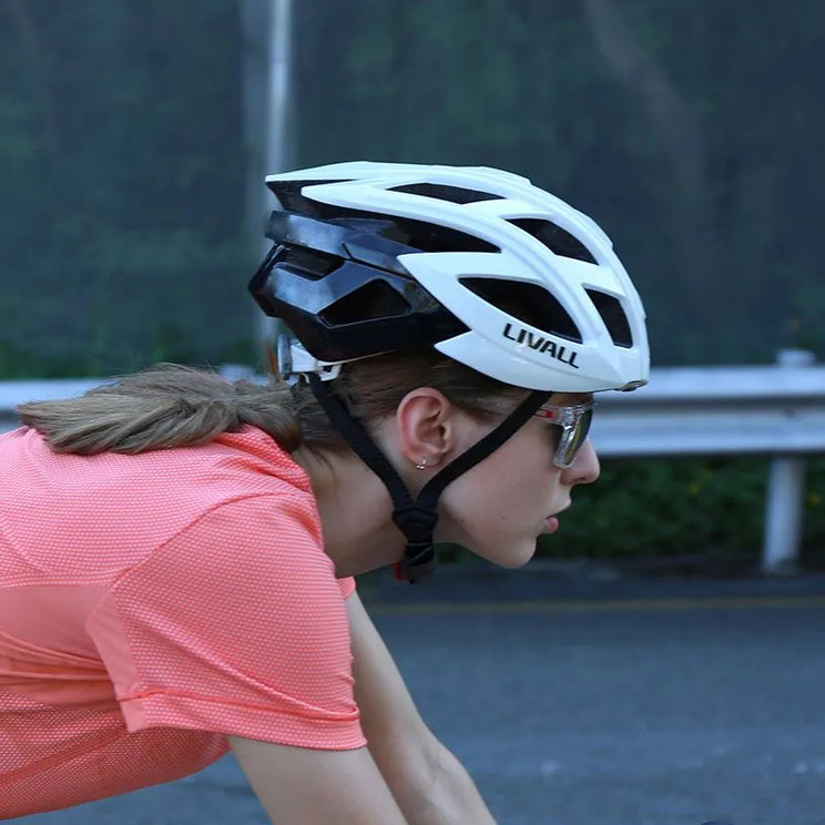 A rider wearing a black and white helmet with 'LIVALL' branding, outdoors.