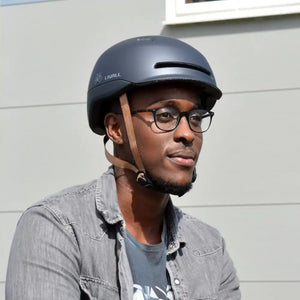 Man wearing the Livall C20 Smart Cycle Helmet in blue while cycling outdoors, showcasing its comfortable fit and modern style.