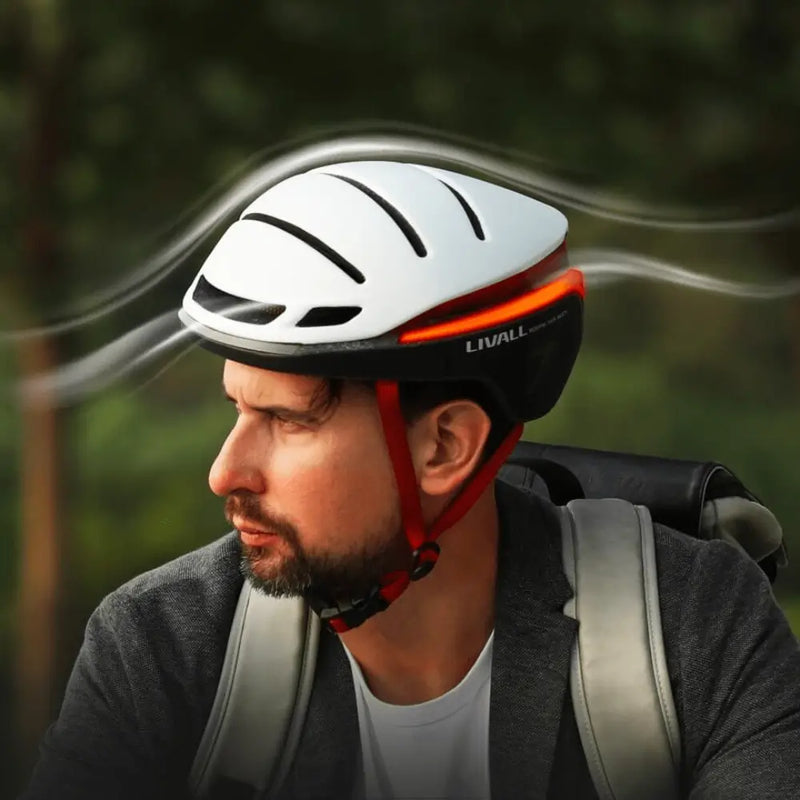 Man wearing the Livall EVO21 smart cycling helmet in white with red straps, designed for aerodynamic performance and safety.
