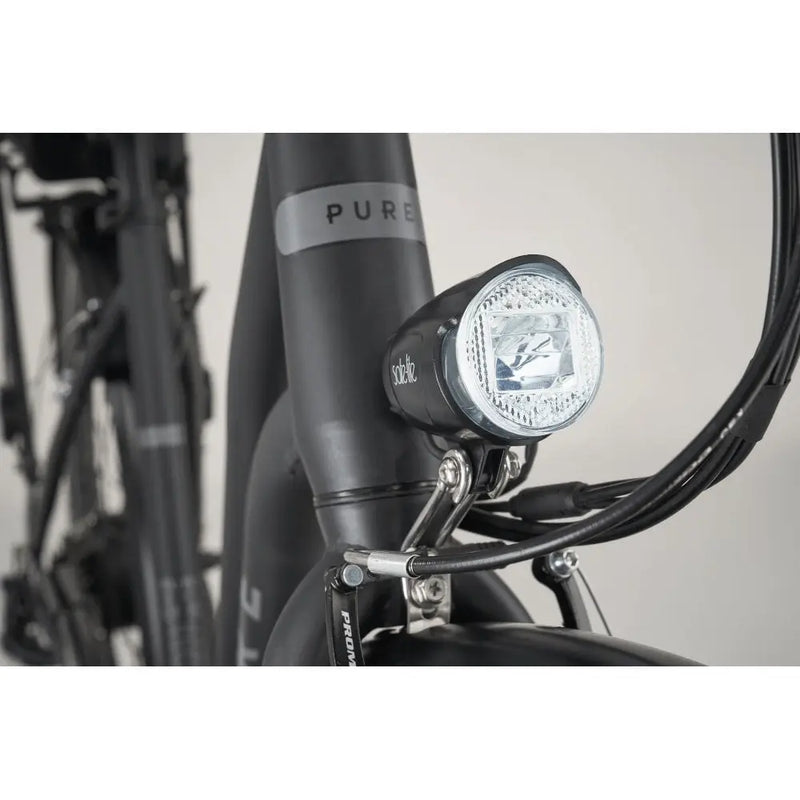 Detail shot of the bright integrated front LED headlight for safe city riding at night.