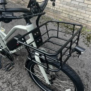Detail shot of the large, sturdy black metal front basket mounted to the frame of the Revom ECargo bike.