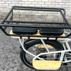 Side close-up of the rear rack system showing the integration of the safety bars, seat cushions, and wooden running boards.