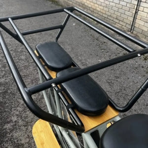 Close-up of the extended rear cargo rack with padded passenger seats and safety protection bars.