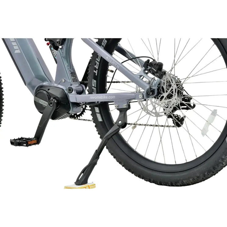 Close-up view of the Bafang M500 mid-drive motor and rear suspension linkage on the grey Revom M1 electric mountain bike.